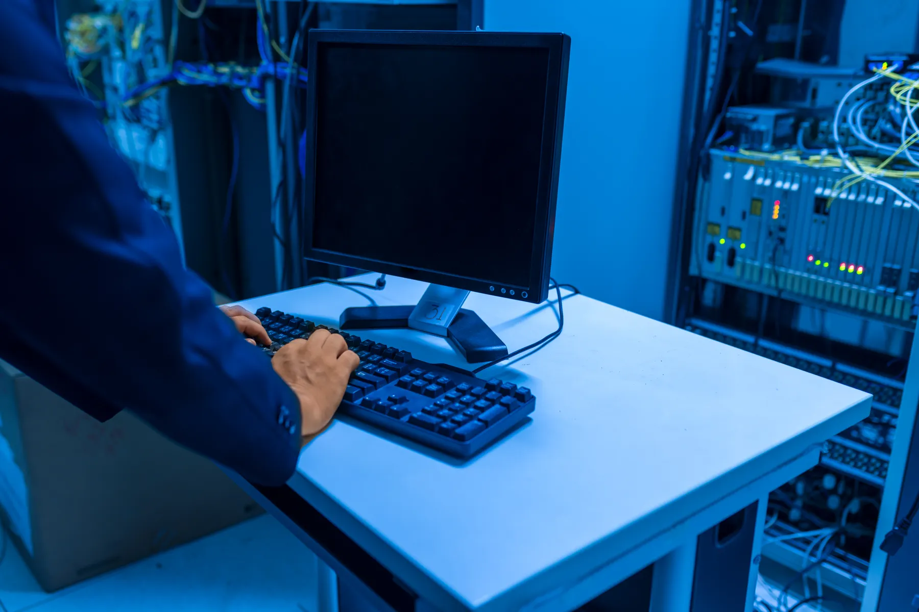 Information technology specialist working beside server equipment in a data center