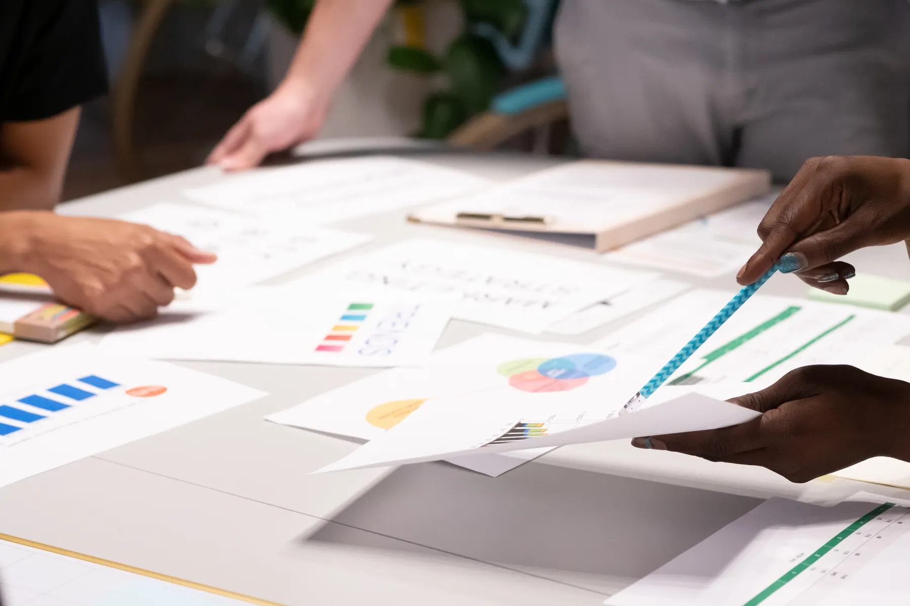 Professional team reviewing operational charts and documents around a meeting table